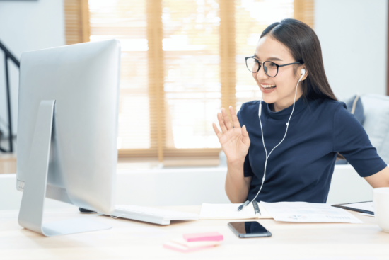 hybrid worker smiling and waving on a remote call