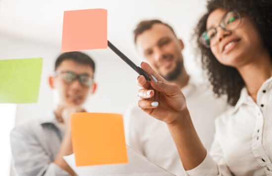 Engaged employees brainstorming ideas on sticky notes