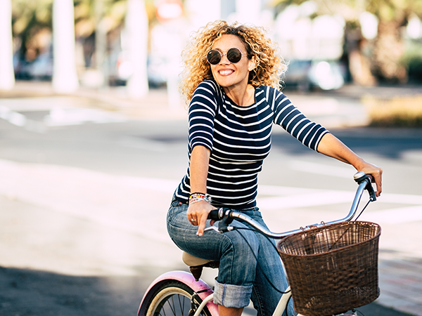 Happy woman riding a bike in the sun