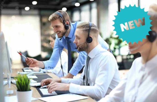 Employees facing computers with headsets on.