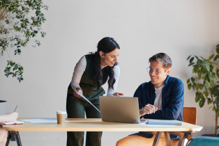 November mProve in 30 webinar image shows one female colleague stood next to a male colleague at a laptop in a work environment